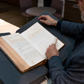 Cultural Heritage Centre - Open book and hand pointing to words