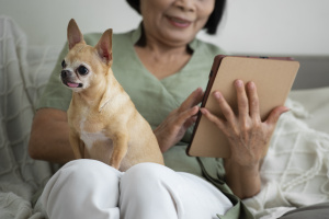 Woman Using Tablet To Register Dog